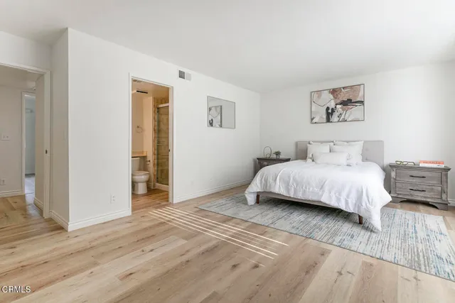 a bedroom with a large bed and a wooden floor