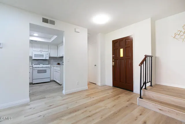 a view of a kitchen with wooden floor and electronic appliances