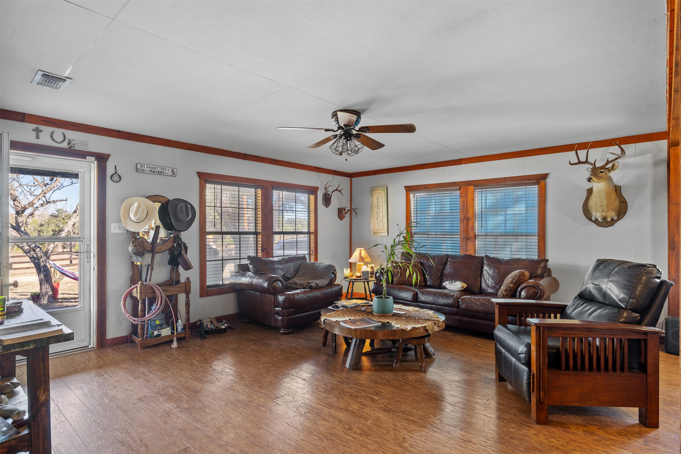 641 Patterson Creek Road Leakey, TX 78873 - Photo 20 of 31 Living room featuring ceiling fan, wood-type flooring, plenty of natural light, and crown molding