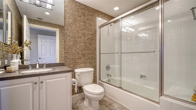 a bathroom with a granite countertop sink toilet and shower