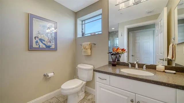 a bathroom with a granite countertop toilet sink and a mirror