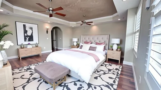 a spacious bedroom with a bed a chandelier and a window