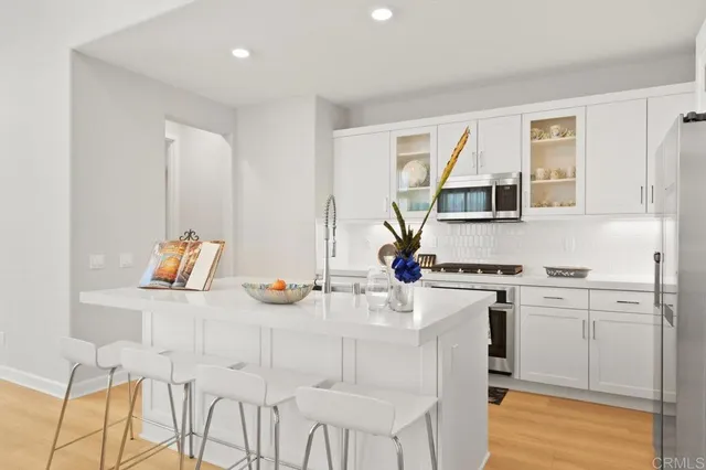 a kitchen with stainless steel appliances granite countertop a stove a sink dishwasher and a refrigerator