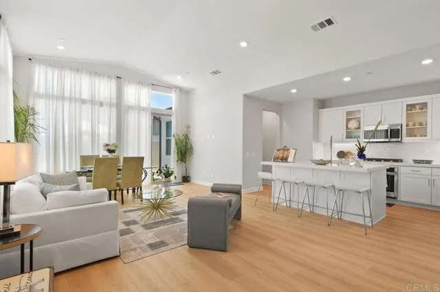 a living room with furniture wooden floor and a large window