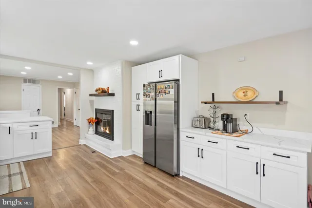 a kitchen with a refrigerator a sink and dishwasher with wooden floor