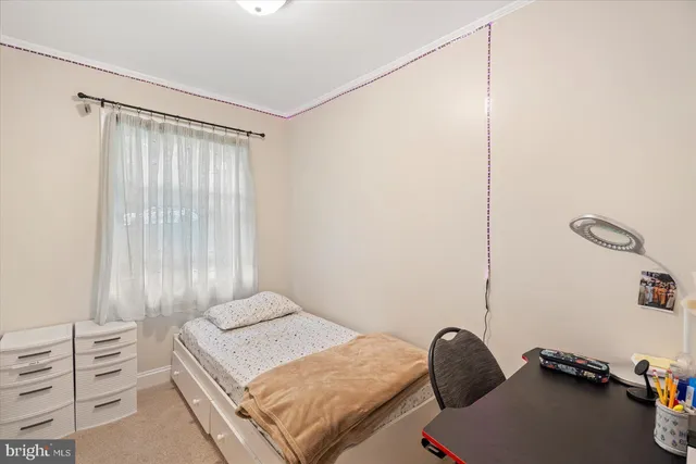 a view of a bedroom with baby bed and chair in it