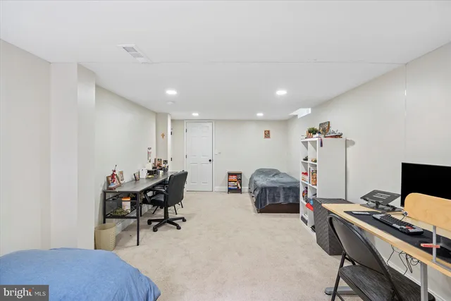 a living room with flat screen tv and a refrigerator