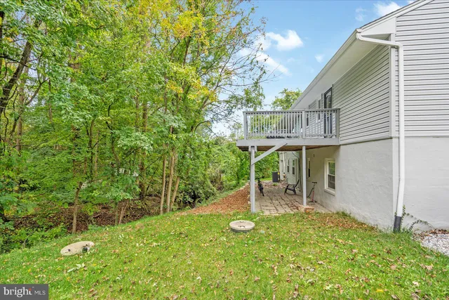 a front view of house with yard and trees in the background