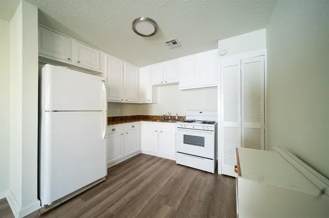 a view of empty room with wooden floor and window