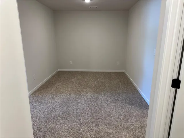 an empty room with closet and entryway