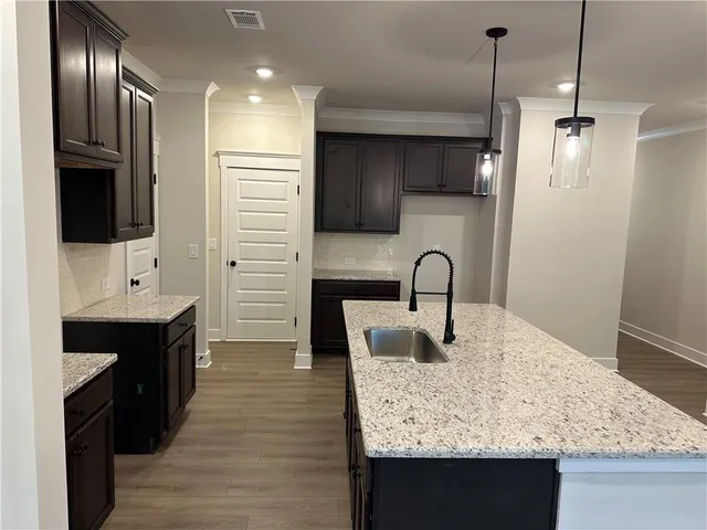 a kitchen with granite countertop a sink cabinetry and granite counter tops