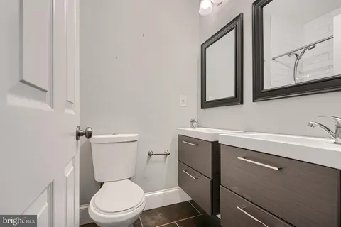 a bathroom with a toilet a sink and mirror
