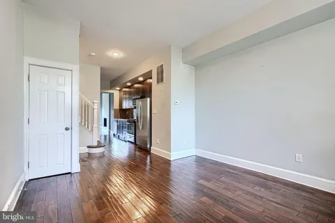 a view of empty room with wooden floor