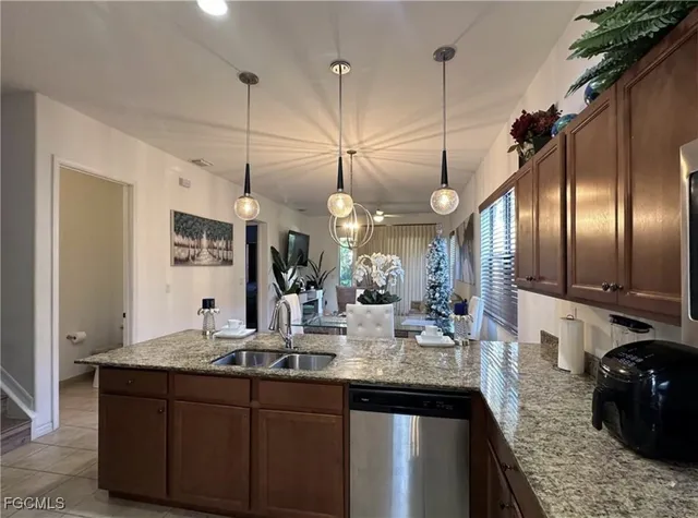 a kitchen with granite countertop a sink cabinets and stainless steel appliances