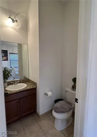 a bathroom with a granite countertop toilet sink and mirror