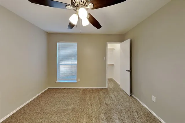 an empty room with closet and windows