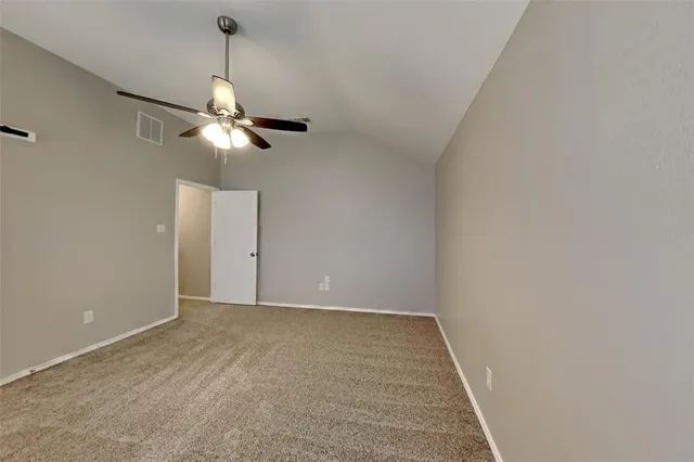 a view of an empty room with a chandelier fan
