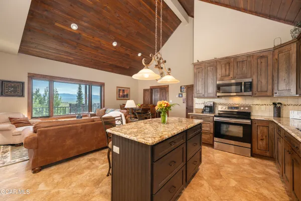 a large kitchen with stainless steel appliances granite countertop a stove sink and cabinets