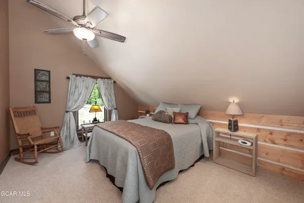 a bedroom with a bed a chandelier and a window