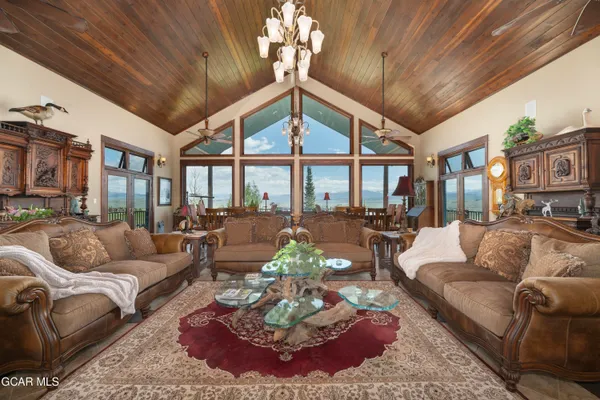 a living room with furniture a fireplace and a chandelier
