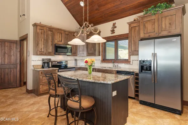 a kitchen with stainless steel appliances granite countertop a sink a stove and a refrigerator