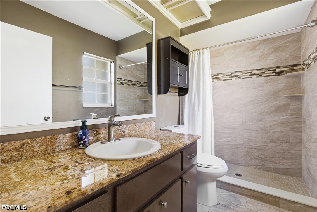 4960 20th Place Southwest Naples, FL 34116 - Photo 16 of 33 a bathroom with a granite countertop sink toilet and shower