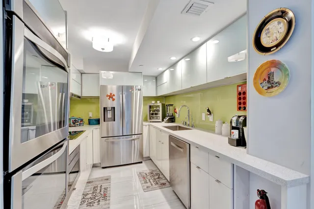 a kitchen with stainless steel appliances granite countertop a refrigerator and a sink
