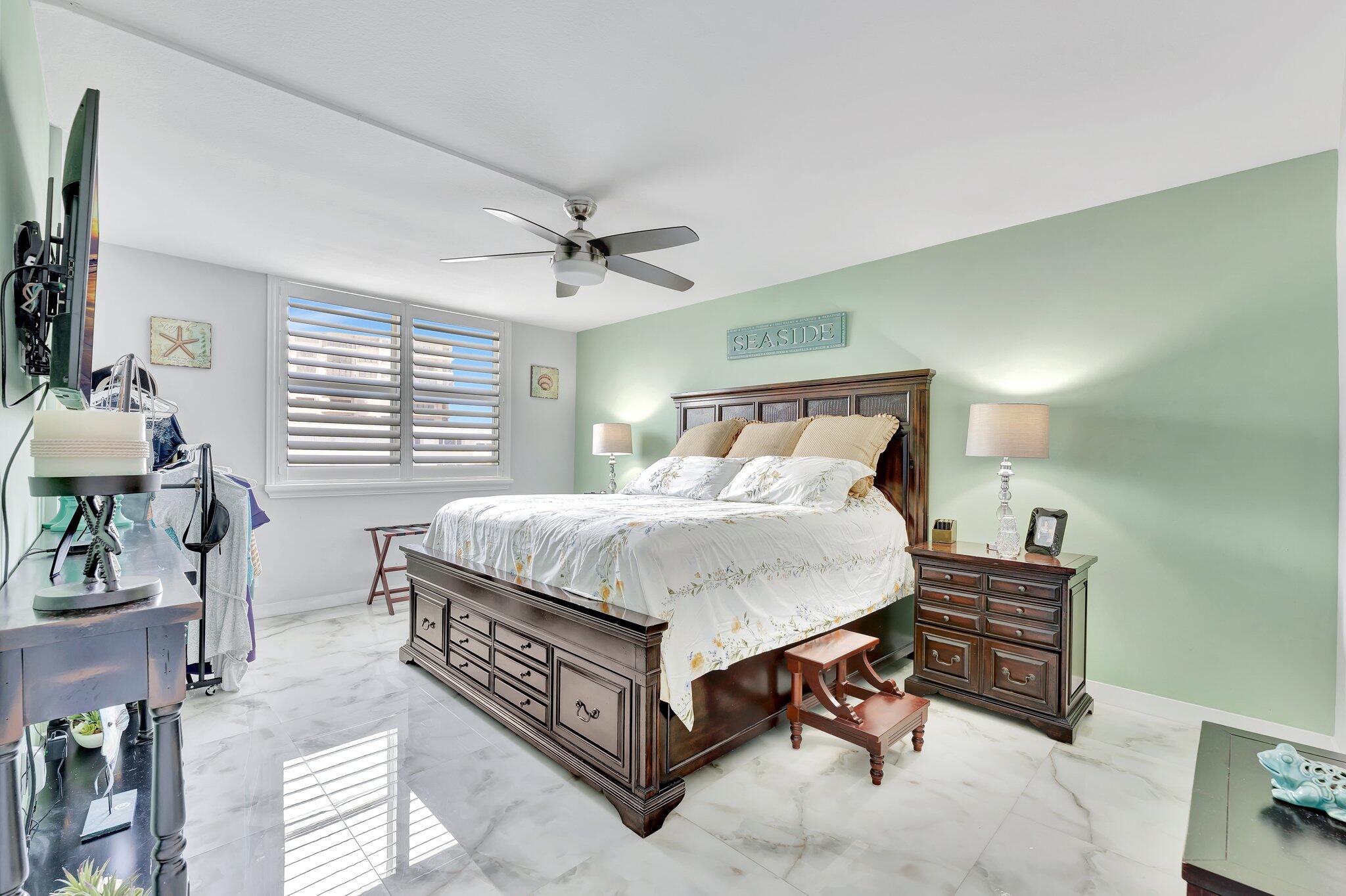 1900 South Ocean Boulevard, Unit 8G Pompano Beach, FL 33062 - Photo 21 of 54 a bedroom with a bed and a chandelier
