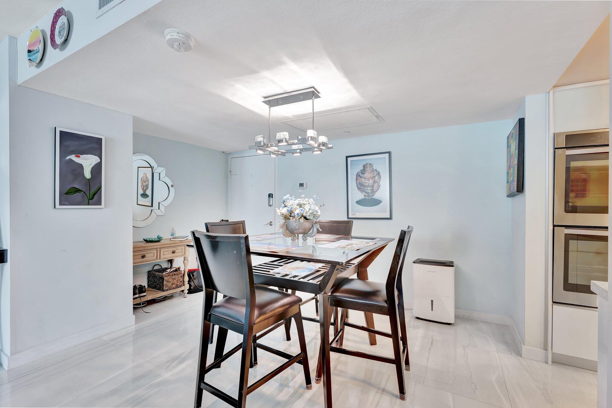 1900 South Ocean Boulevard, Unit 8G Pompano Beach, FL 33062 - Photo 7 of 54 a view of a dining room with furniture and chandelier