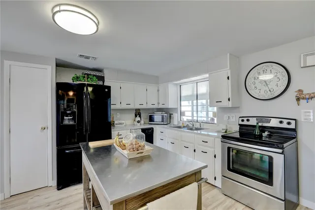 a kitchen with a table chairs a stove a refrigerator and a window