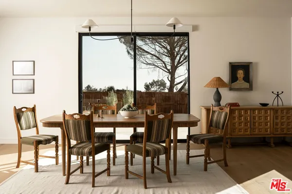 a dining room with furniture and a floor to ceiling window
