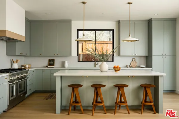 a kitchen with furniture a sink a window and stainless steel appliances