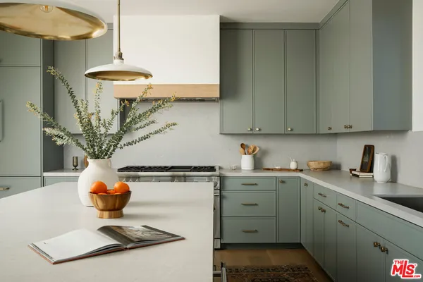 a kitchen with stainless steel appliances granite countertop a sink a stove and a wooden floors