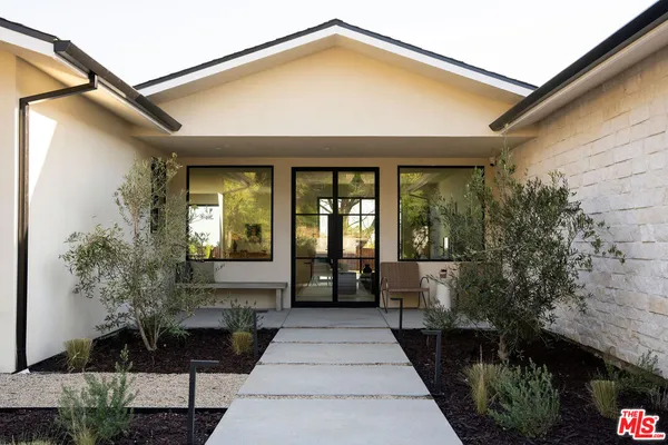 a front view of a house with a garden