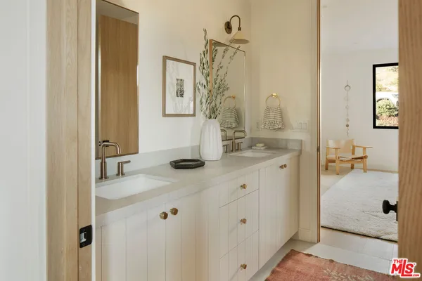 a en suite bathroom with a granite countertop sink and a mirror
