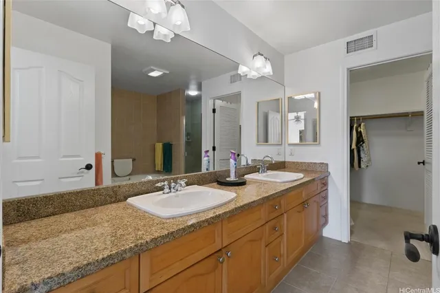 a bathroom with a granite countertop sink a large mirror and shower
