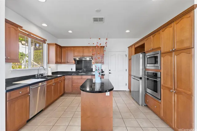 a kitchen with stainless steel appliances granite countertop a refrigerator and a sink