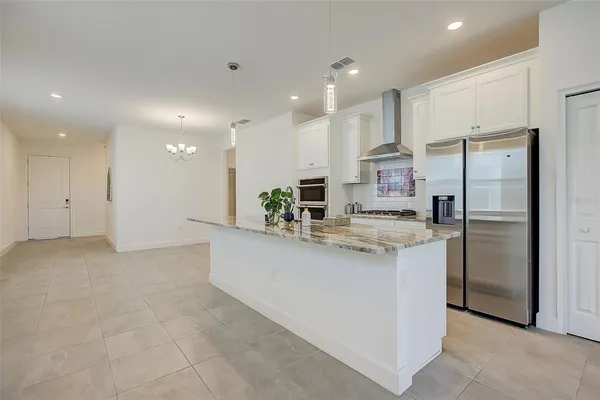 a large kitchen with granite countertop a large counter top stainless steel appliances and cabinets