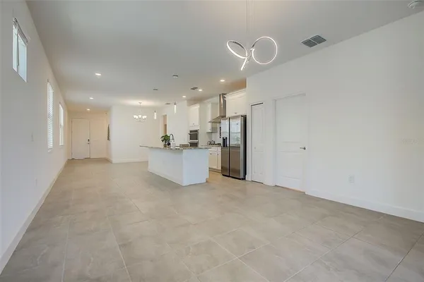 a kitchen with stainless steel appliances kitchen island granite countertop a stove a refrigerator and a white cabinets