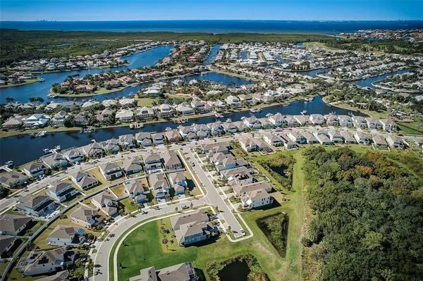 an aerial view of a city with lots of residential buildings ocean and mountain view in back