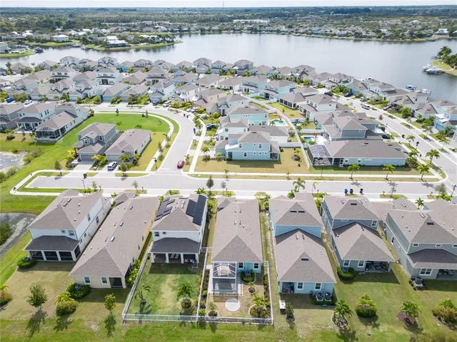 an aerial view of residential houses with outdoor space and lake view