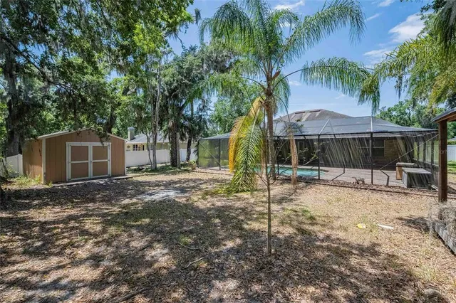 a backyard of a house with table and chairs under an umbrella