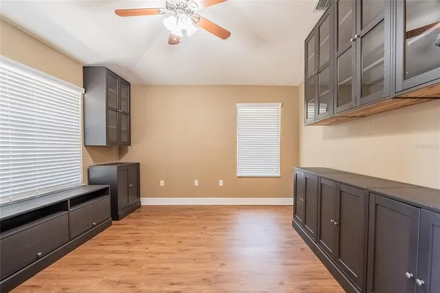a view of an empty room with window and wooden floor