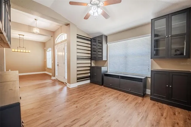 a view of an empty room with a window and wooden floor