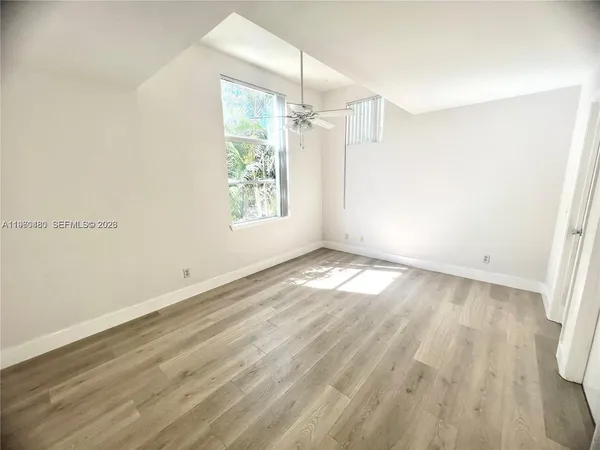 a view of empty room with wooden floor
