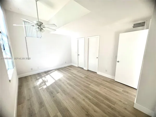 a view of empty room with wooden floor