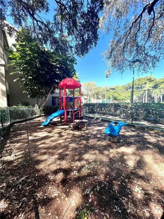 a view of a lake with a yard and large trees