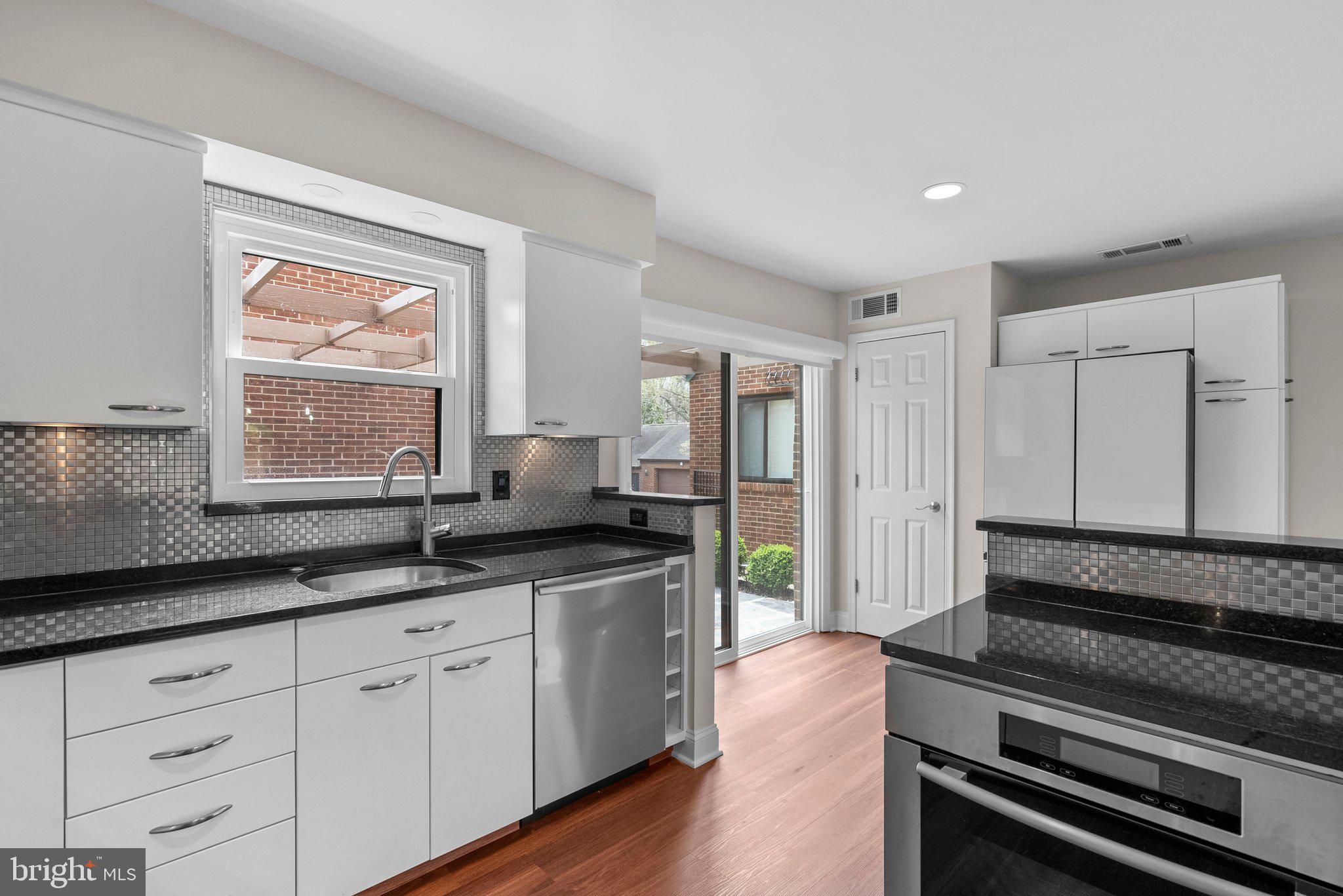 11310 Harborside Cluster Reston, VA 20191 - Photo 22 of 74 a kitchen with granite countertop white cabinets and white appliances