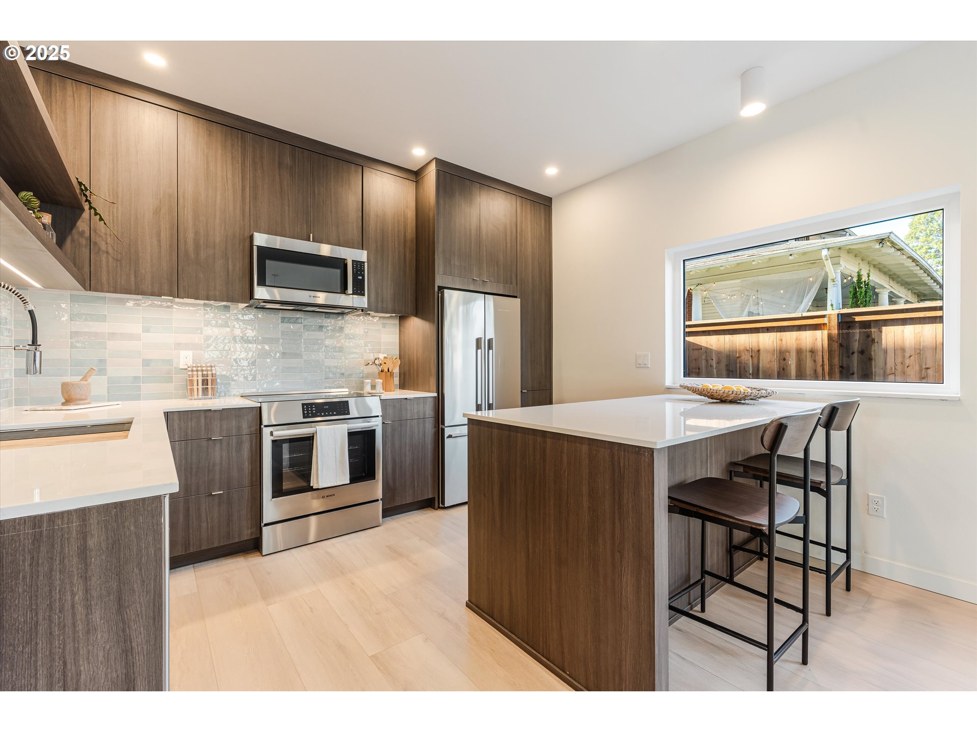 5490 Southeast Boise Street Portland, OR 97206 - Photo 11 of 48 a kitchen with stainless steel appliances kitchen island granite countertop a stove a sink and a microwave
