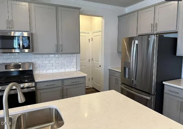 a kitchen with stainless steel appliances a refrigerator sink and cabinets